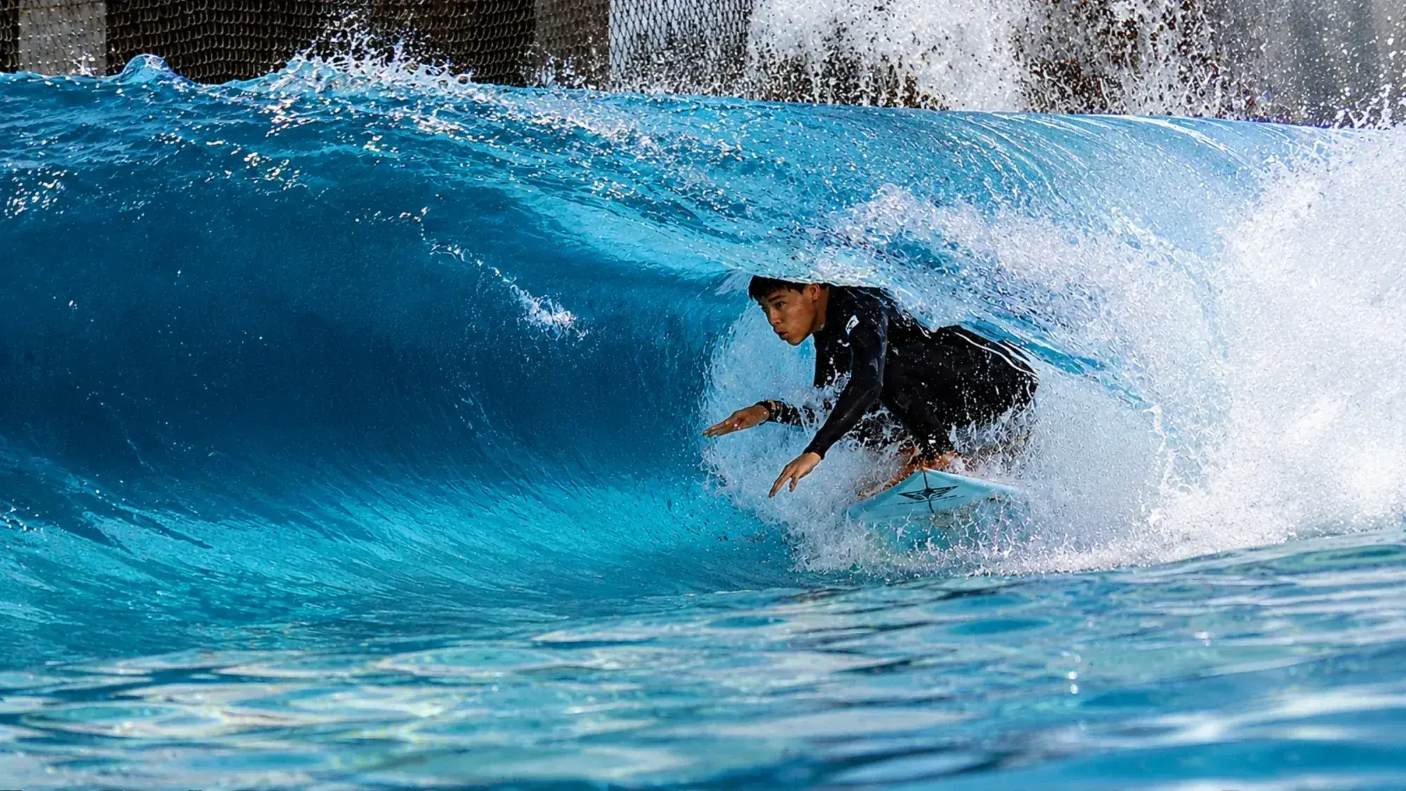 Surfista dentro do clube Surf Center na onda indoor aquecida e programável