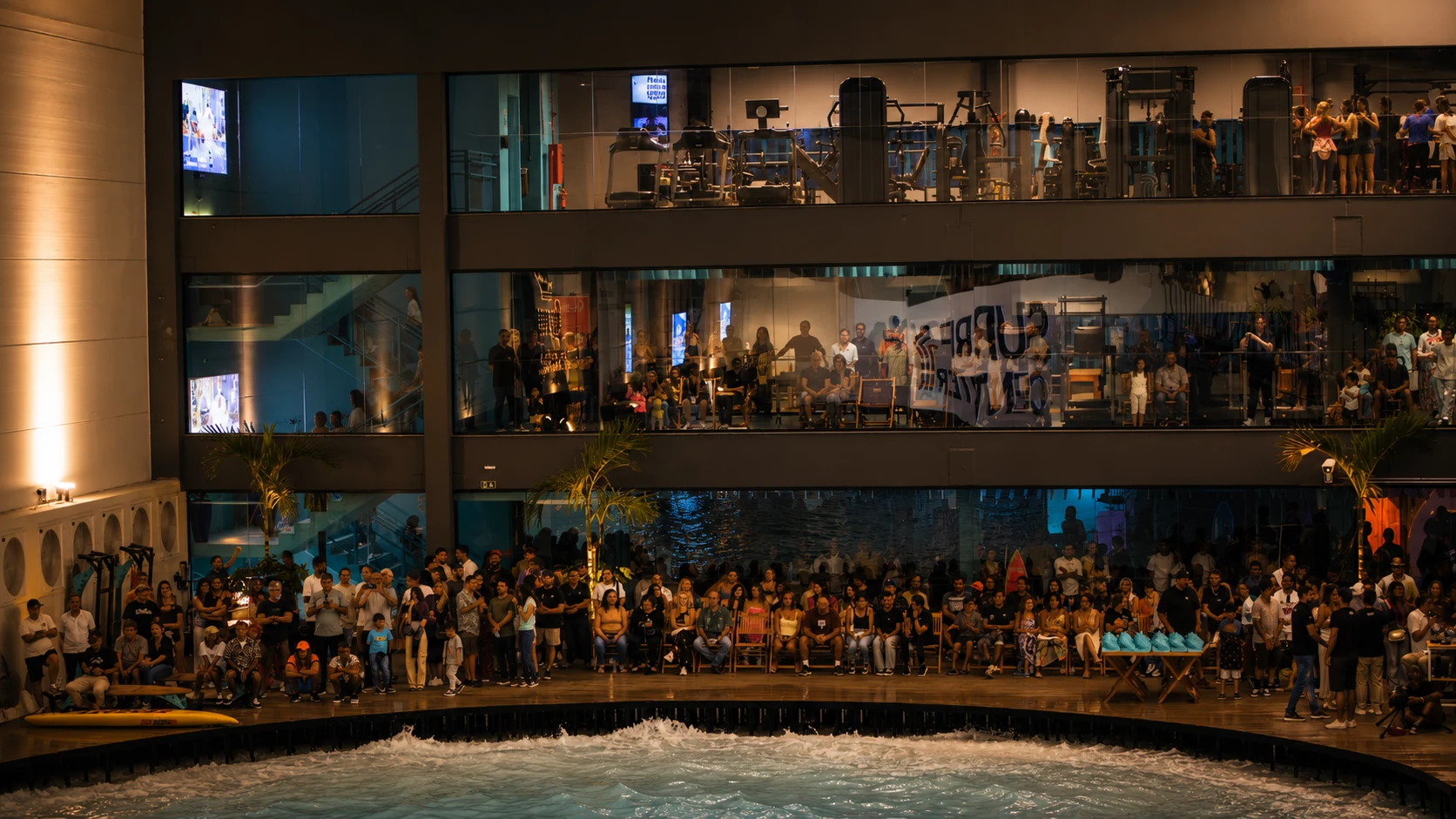 Estrutura Surf Center: ambiente interno com surfistas e lounge ao fundo